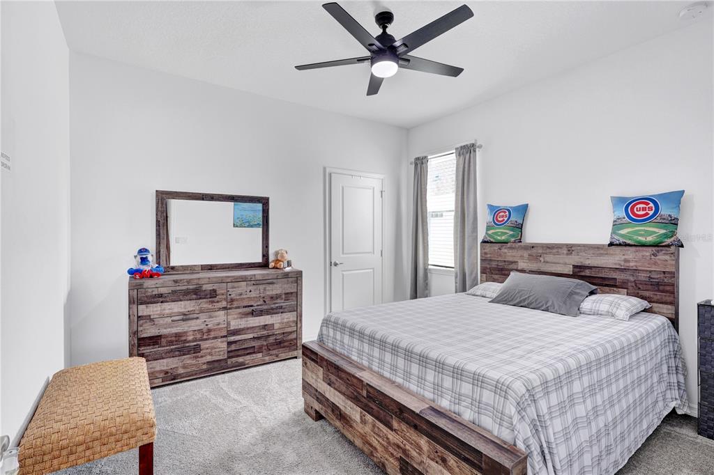 7185 Southwest 63rd Street Ocala, FL 34474 - Photo 20 of 31 a bedroom with a bed and a chandelier