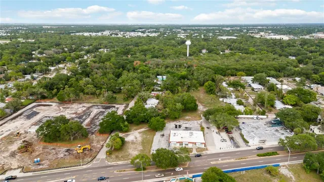 an aerial view of residential houses with outdoor space and trees