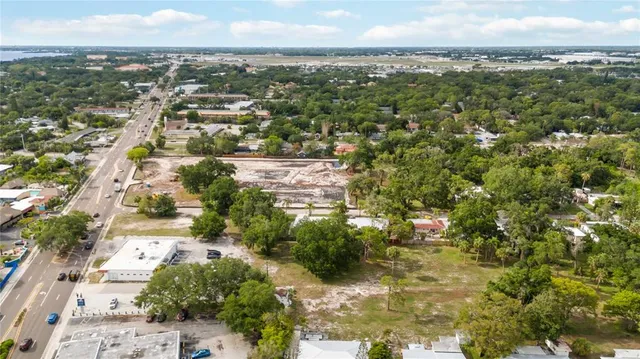 an aerial view of residential houses with outdoor space and trees