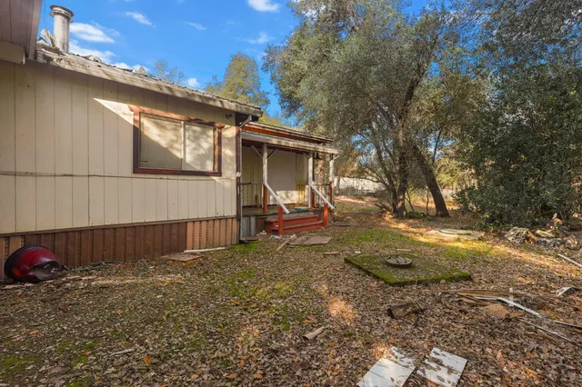 a view of a house with backyard and trees