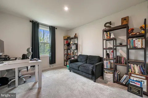 a living room with furniture a bookshelf and a window