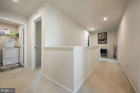 a view of a hallway with closet and a window