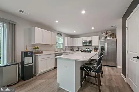 a kitchen with a sink a counter top stainless steel appliances and cabinets