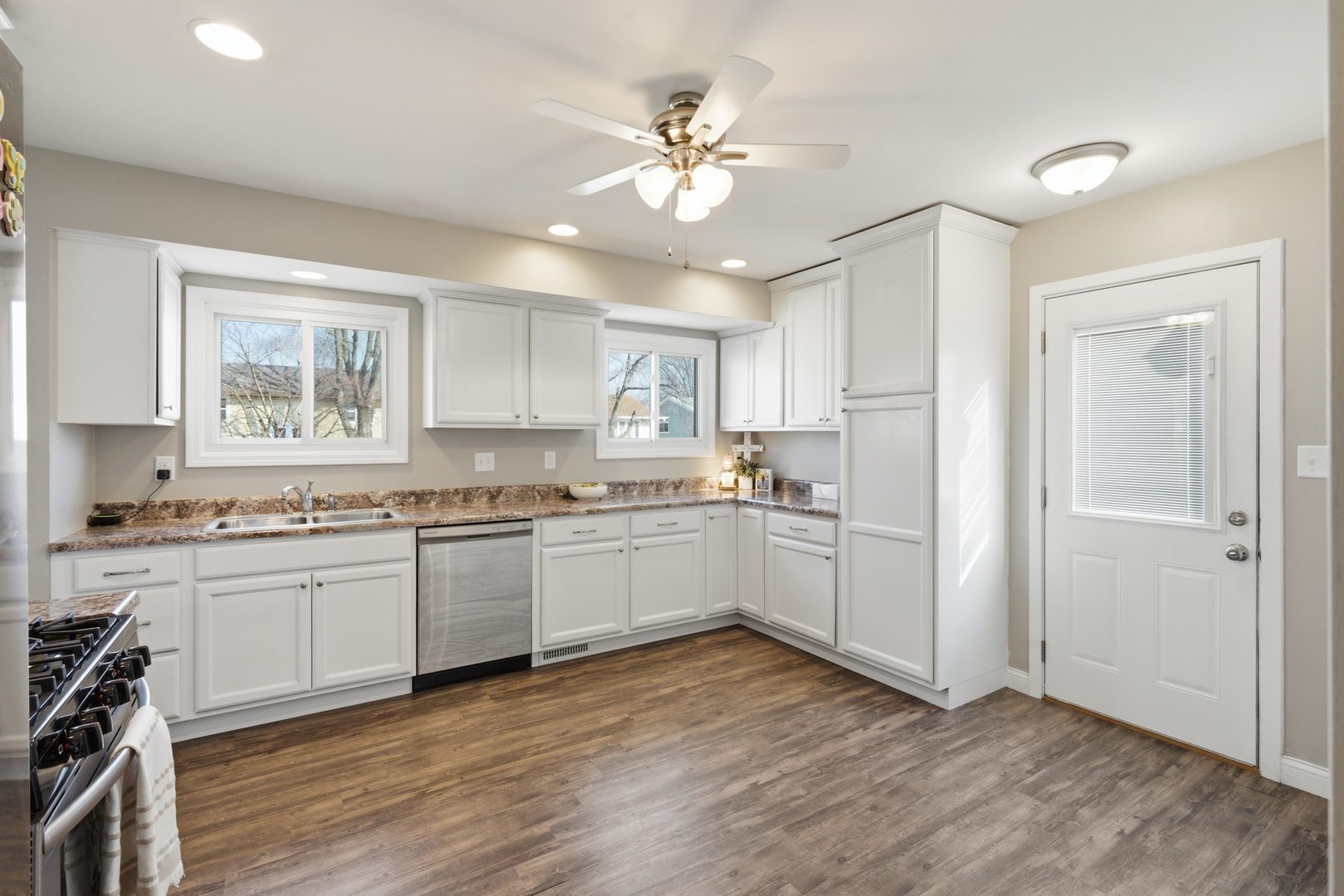 3443 3rd Street B East Moline, IL 61244 - Photo 5 of 23 a kitchen with granite countertop a stove a sink dishwasher and a refrigerator with wooden floor