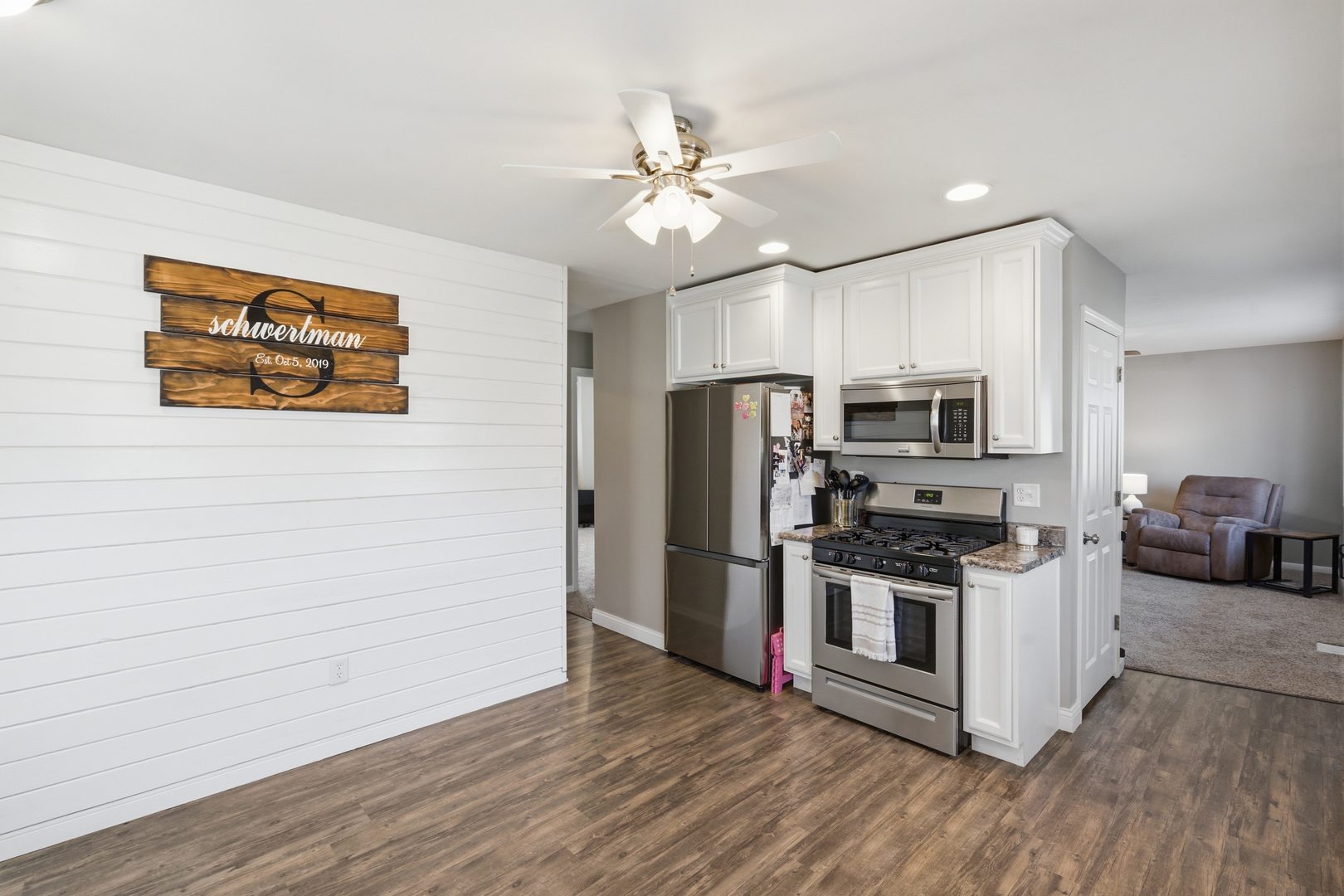3443 3rd Street B East Moline, IL 61244 - Photo 7 of 23 a kitchen with stainless steel appliances a stove a microwave and white cabinets