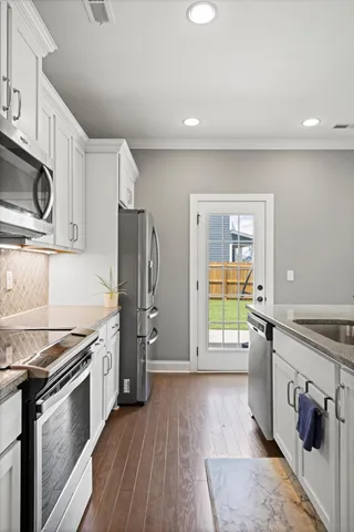 a kitchen with stainless steel appliances granite countertop a refrigerator and a stove top oven
