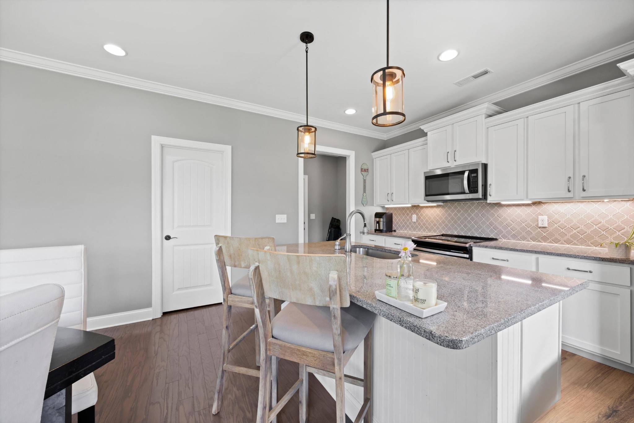 3569 Weathervane Loop Apison, TN 37302 - Photo 14 of 36 a kitchen with stainless steel appliances granite countertop a sink a stove a dining table and chairs with wooden floor