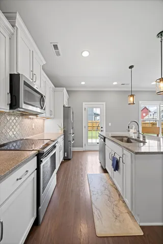a large kitchen with stainless steel appliances granite countertop a stove and a sink