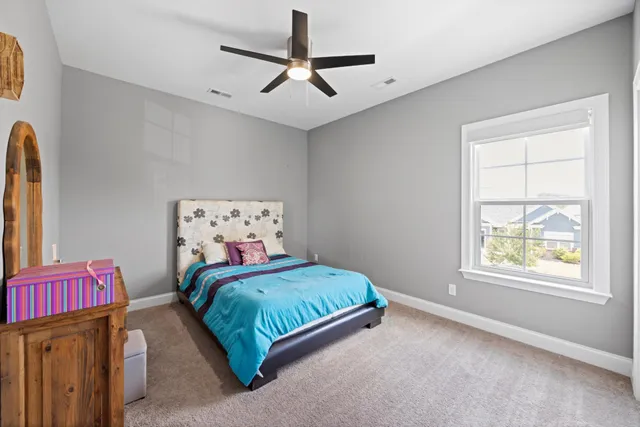 a bedroom with a bed a window and flowerpot