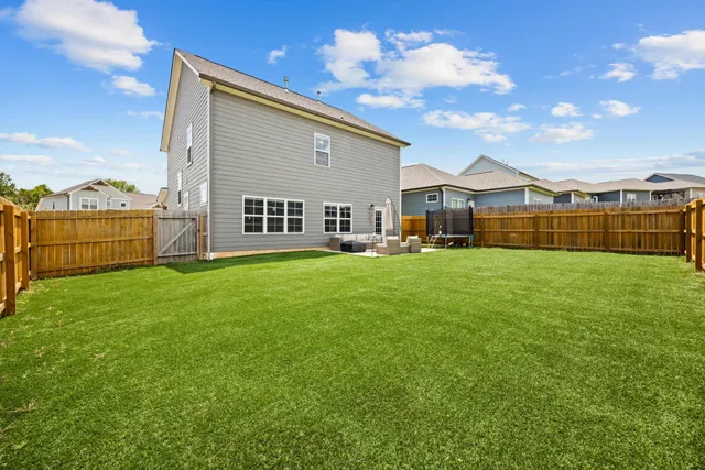 a view of a house with a big yard and large trees