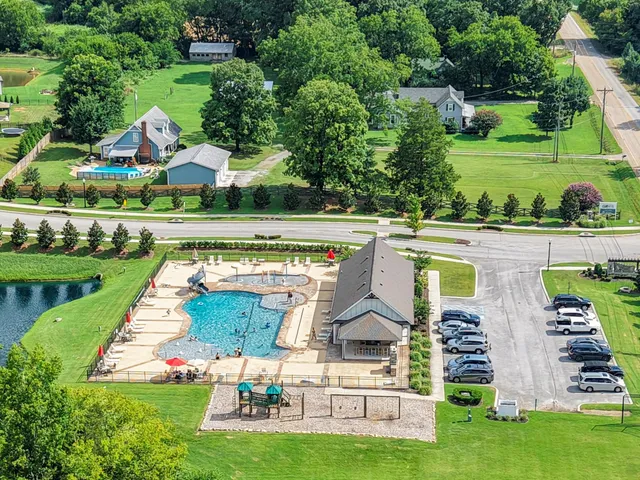 a view of swimming pool with a garden and plants