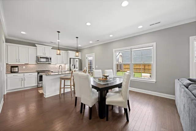 a kitchen with a table chairs refrigerator and cabinets