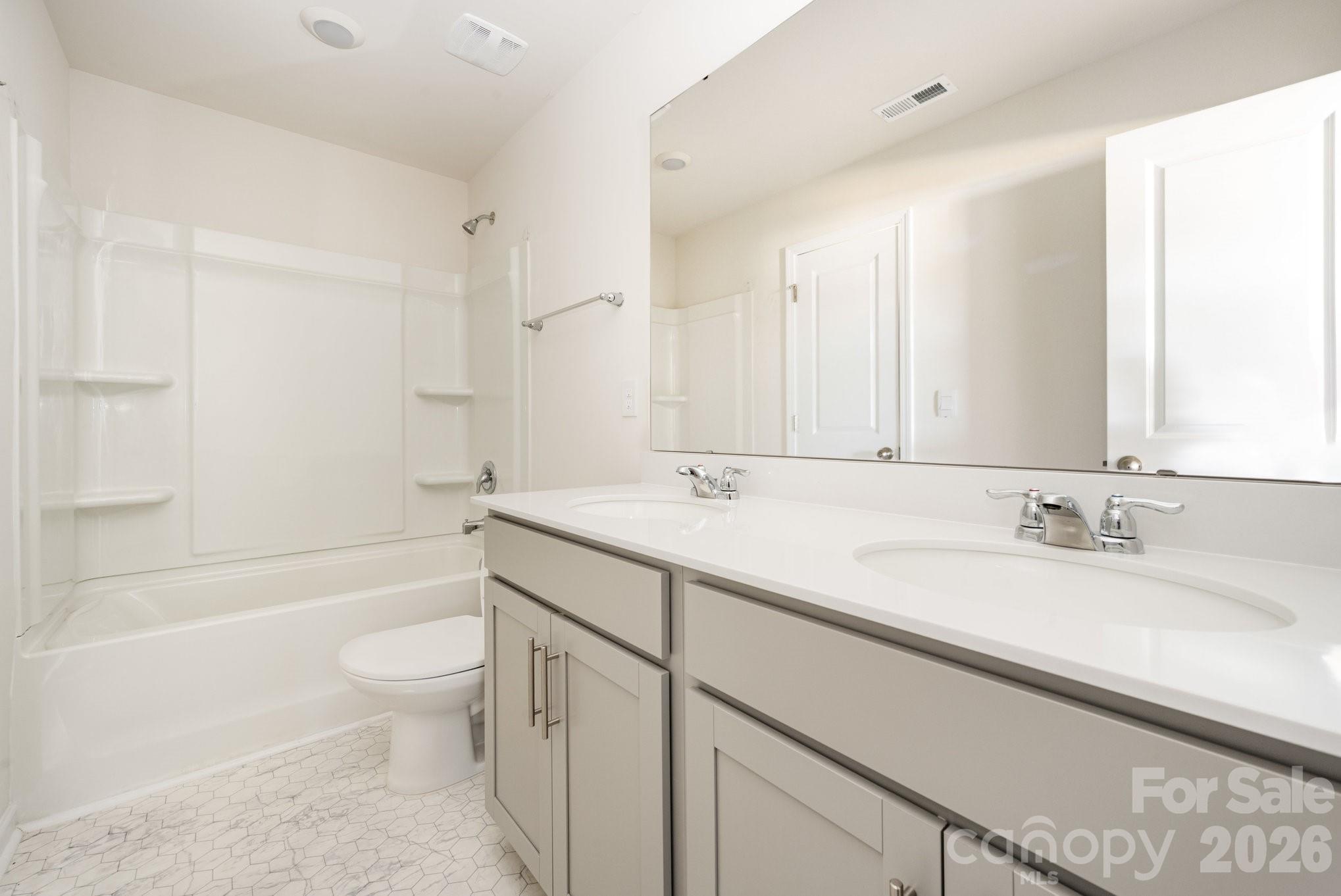 2116 Vanderlyn Street Monroe, NC 28112 - Photo 18 of 20 a bathroom with a granite countertop sink a toilet and bathtub
