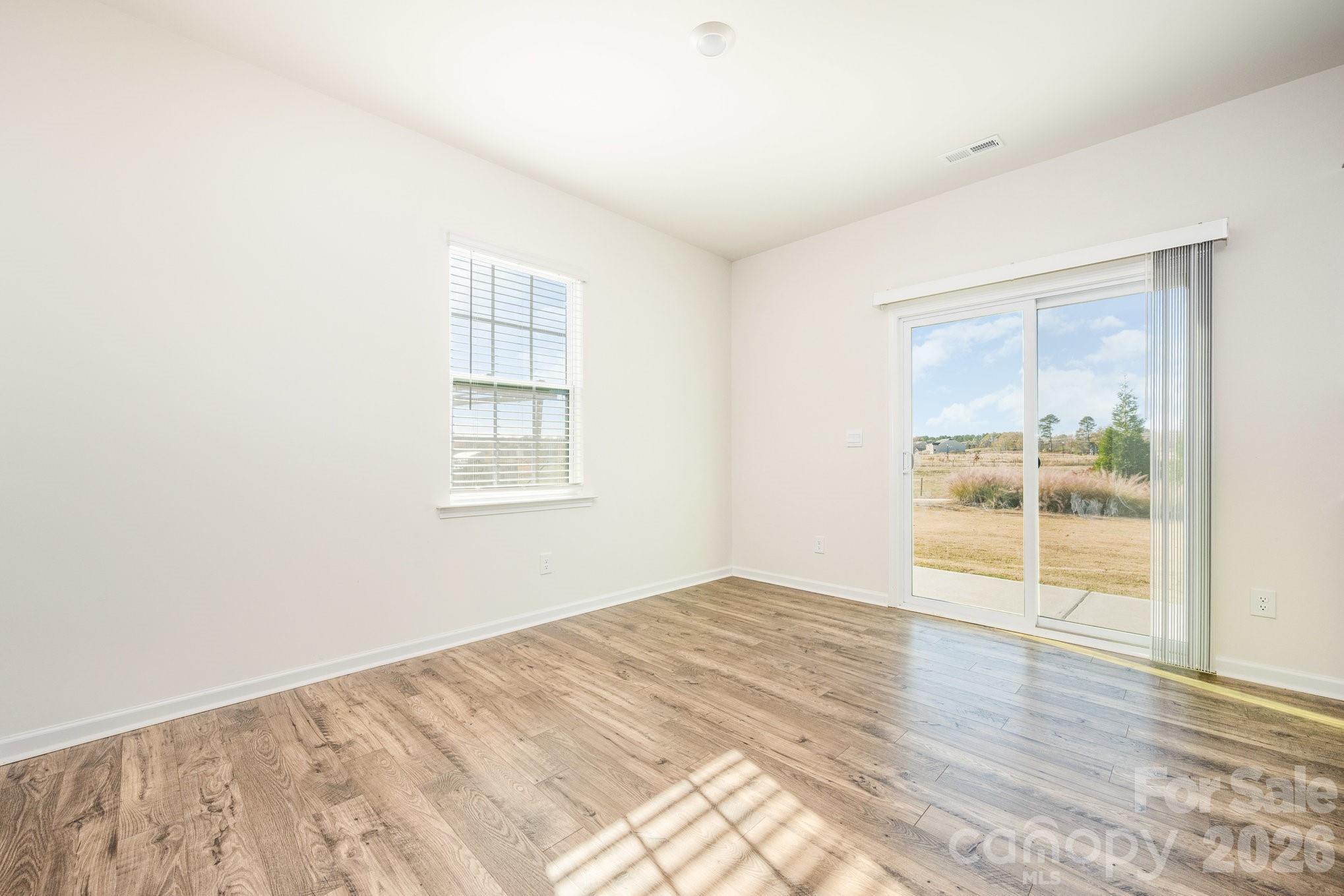 2116 Vanderlyn Street Monroe, NC 28112 - Photo 8 of 20 a view of an empty room with wooden floor and a window