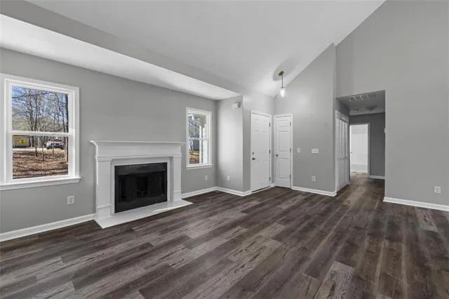 a view of empty room with wooden floor and fireplace