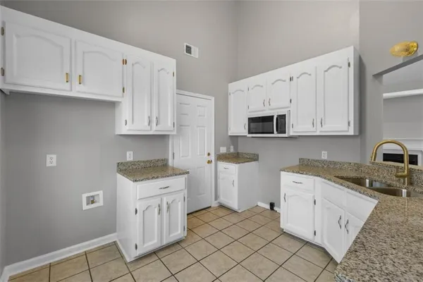 a kitchen with white cabinets appliances and sink