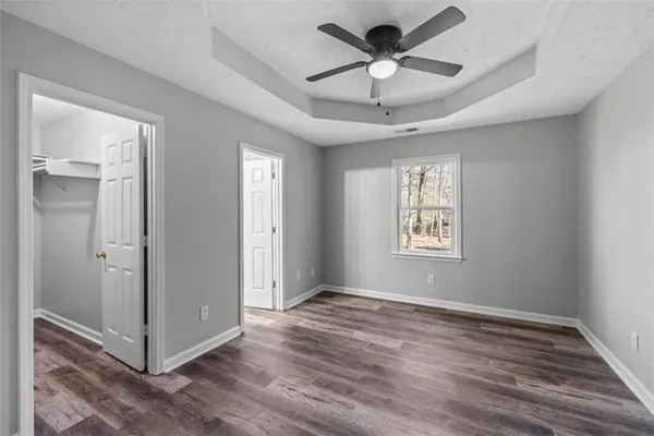 a view of an empty room with a window and wooden floor