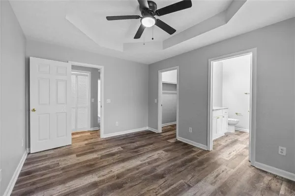 a view of hallway with a chandelier fan and wooden floor