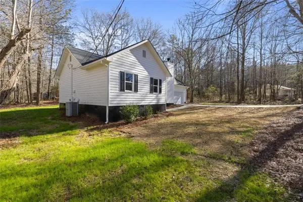 a view of a house with backyard and trees