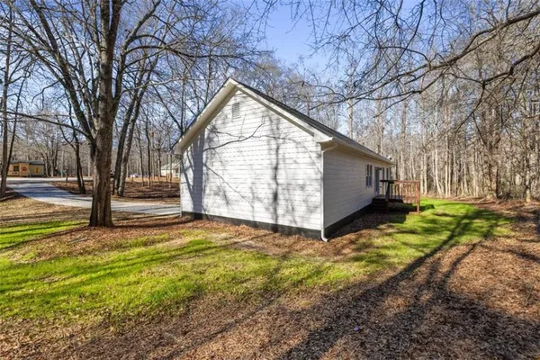 a view of backyard with tree and wooden fence