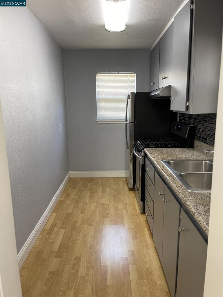 1705 Linden Street Oakland, CA 94607 - Photo 6 of 22 a kitchen with a sink a microwave a refrigerator and cabinets