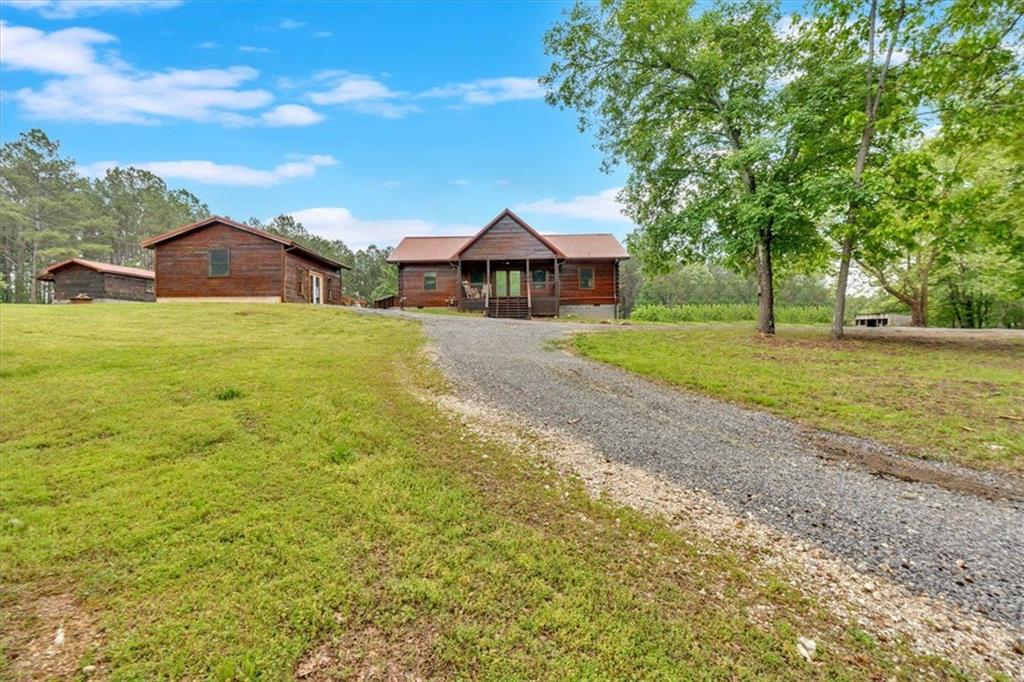 a view of a large house with a big yard and large trees