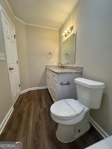 a white toilet sitting next to a bathroom sink and a mirror