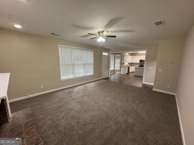 a view of a livingroom with a ceiling fan and window