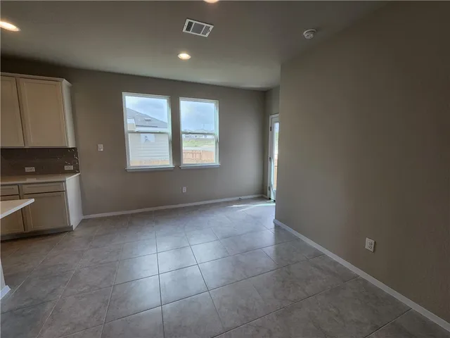 a view of an empty room with a kitchen