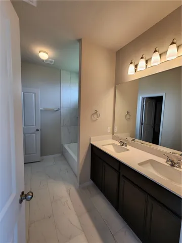 a bathroom with a tub sink and mirror