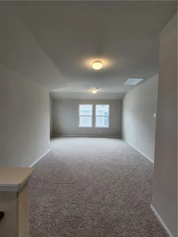 an empty room with closet and a window