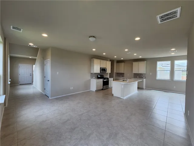 a view of a big room with kitchen and windows