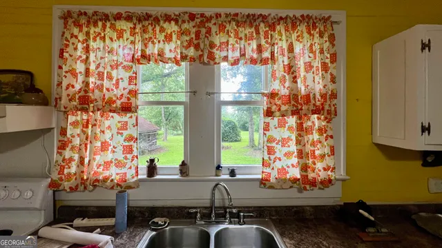 a kitchen with stainless steel appliances a dining table chairs and a refrigerator