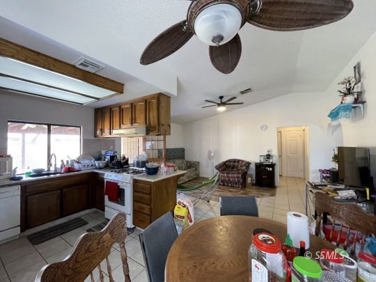 118 Chambers Street Ridgecrest, CA 93555 - Photo 7 of 16 a kitchen with a stove a refrigerator and a dining table