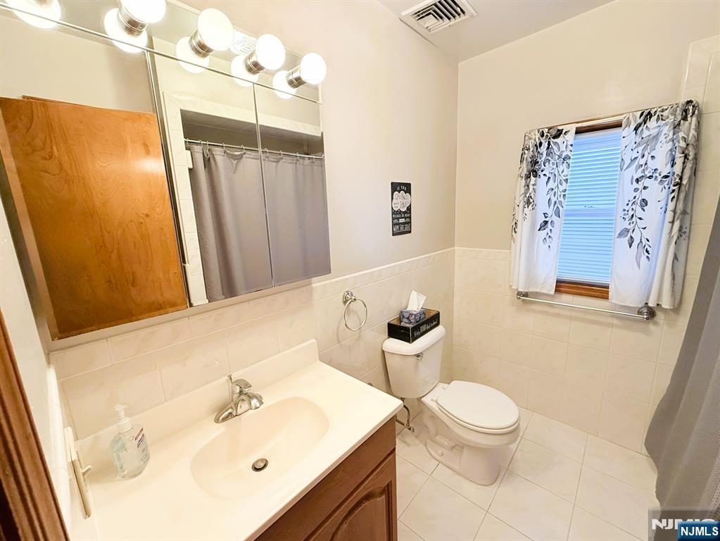 47 Harding Court, Unit 2 Garfield, NJ 07026 - Photo 14 of 34 a bathroom with a sink mirror and toilet