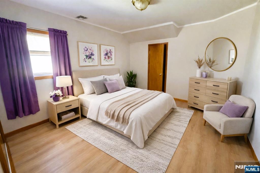 47 Harding Court, Unit 2 Garfield, NJ 07026 - Photo 17 of 34 a bedroom with a bed and dresser with mirror