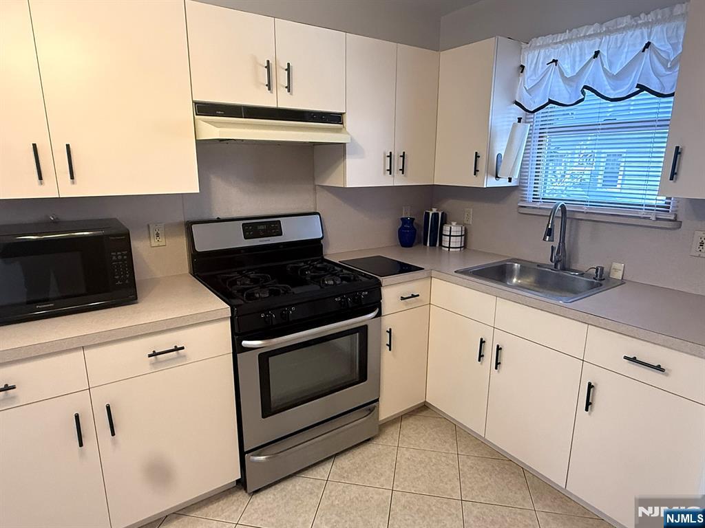 47 Harding Court, Unit 2 Garfield, NJ 07026 - Photo 3 of 34 a kitchen with granite countertop white cabinets and white appliances