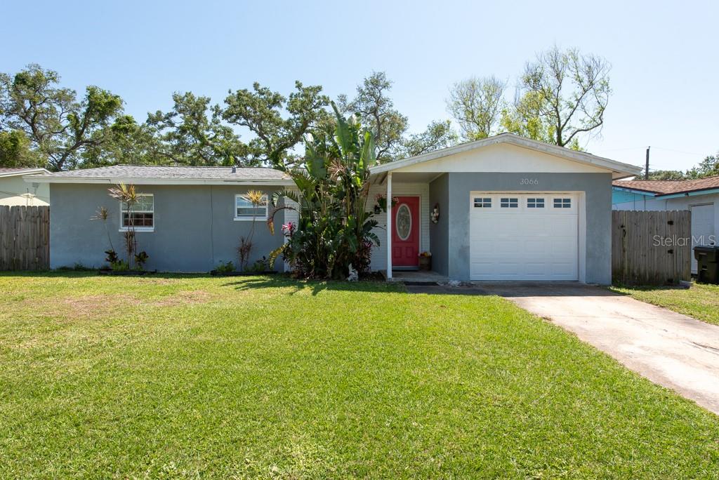 a front view of a house with a garden and yard