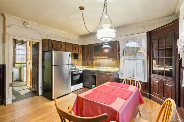 a kitchen with stainless steel appliances kitchen island granite countertop a refrigerator a stove and a sink dishwasher with wooden floor