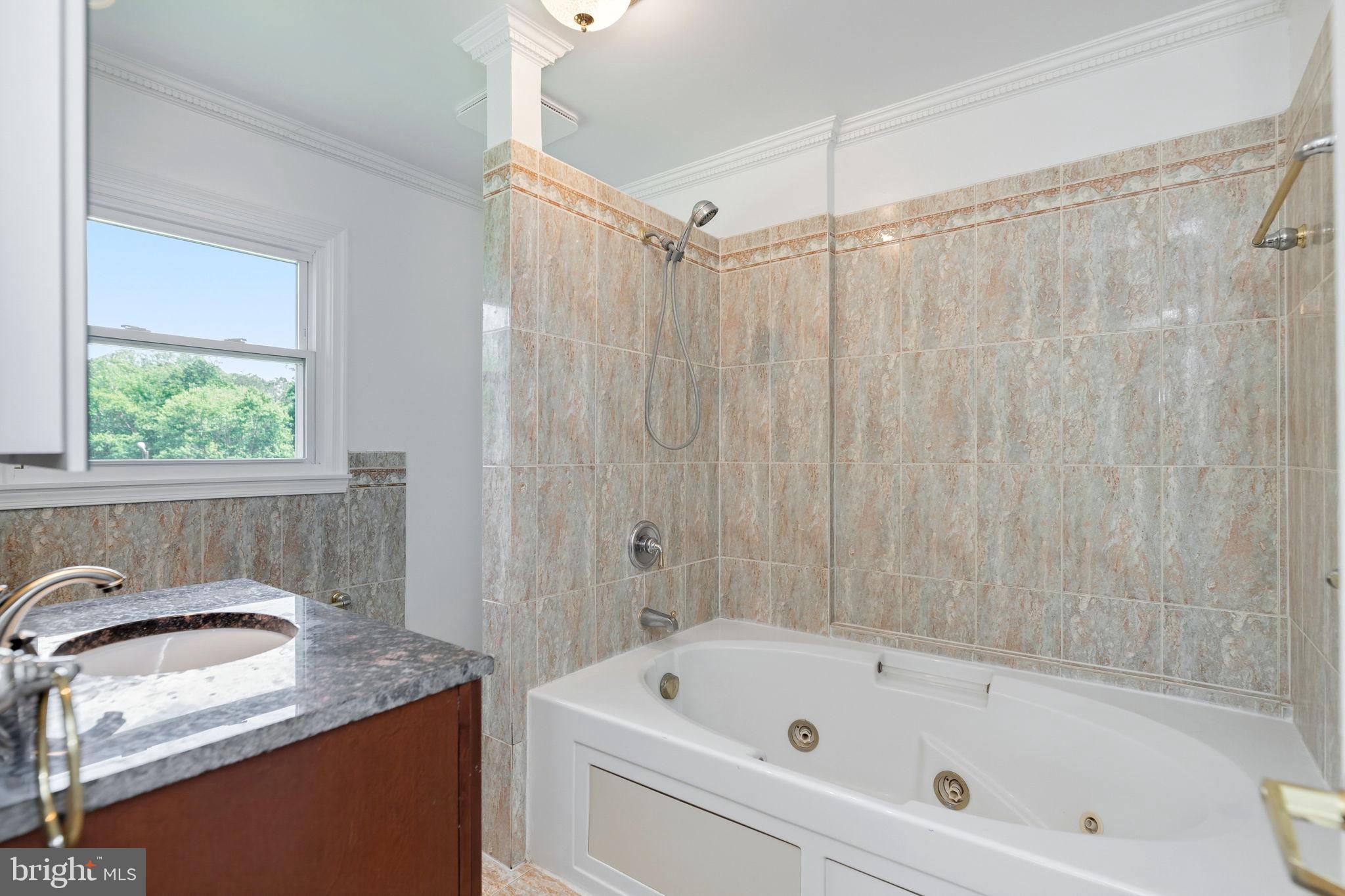 11325 Bacon Race Road Woodbridge, VA 22192 - Photo 30 of 54 a bathroom with a granite countertop sink and a bathtub