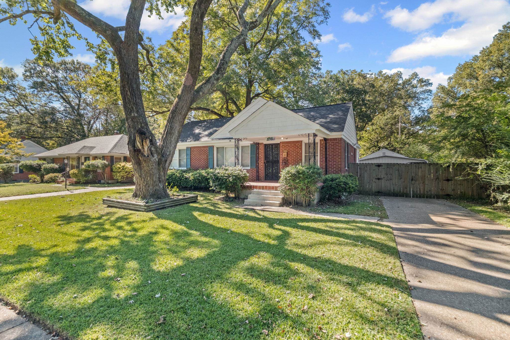 1261 Marcia Road Memphis, TN 38117 - Photo 2 of 27 a front view of a house with swimming pool and green space