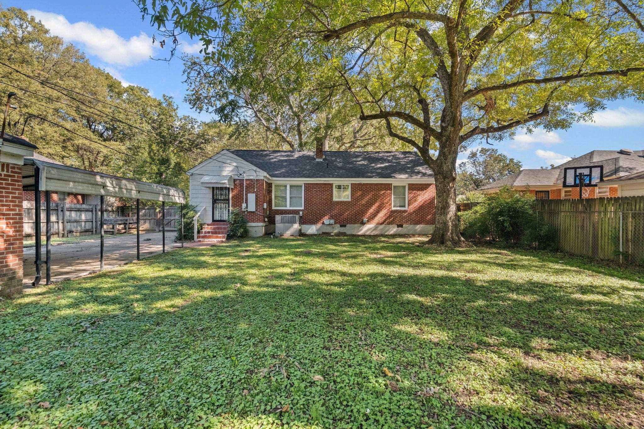 1261 Marcia Road Memphis, TN 38117 - Photo 26 of 27 a front view of a house with a garden and trees