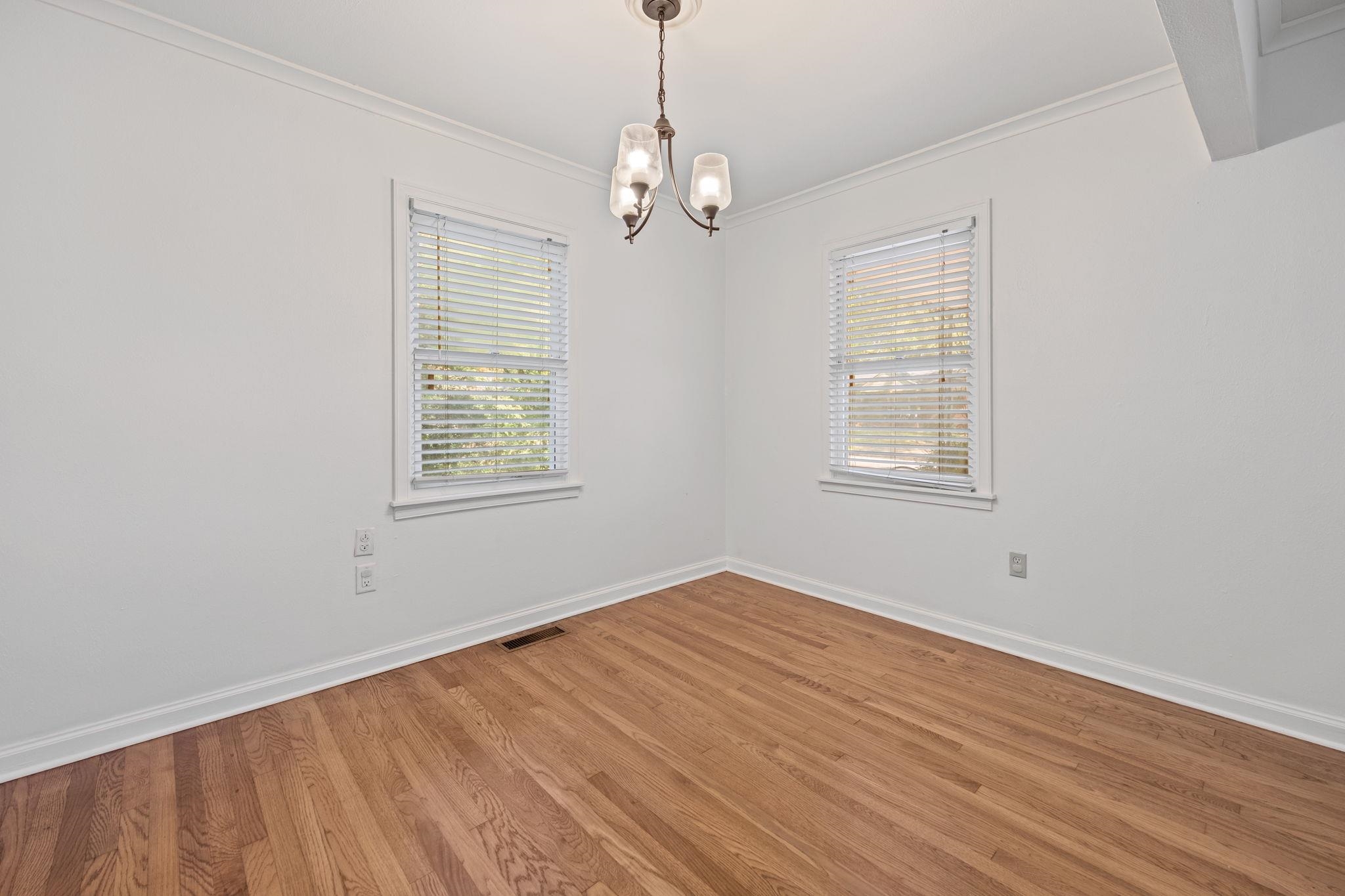 1261 Marcia Road Memphis, TN 38117 - Photo 8 of 27 an empty room with wooden floor windows and exposed bricks
