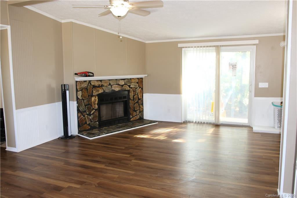 6710 Santa Claus Road Monroe, NC 28110 - Photo 8 of 30 a view of an empty room with wooden floor fireplace and a window