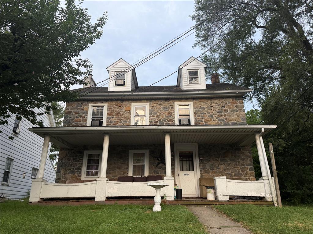 A classic stone facade with dormer windows creates a welcoming curb appeal.