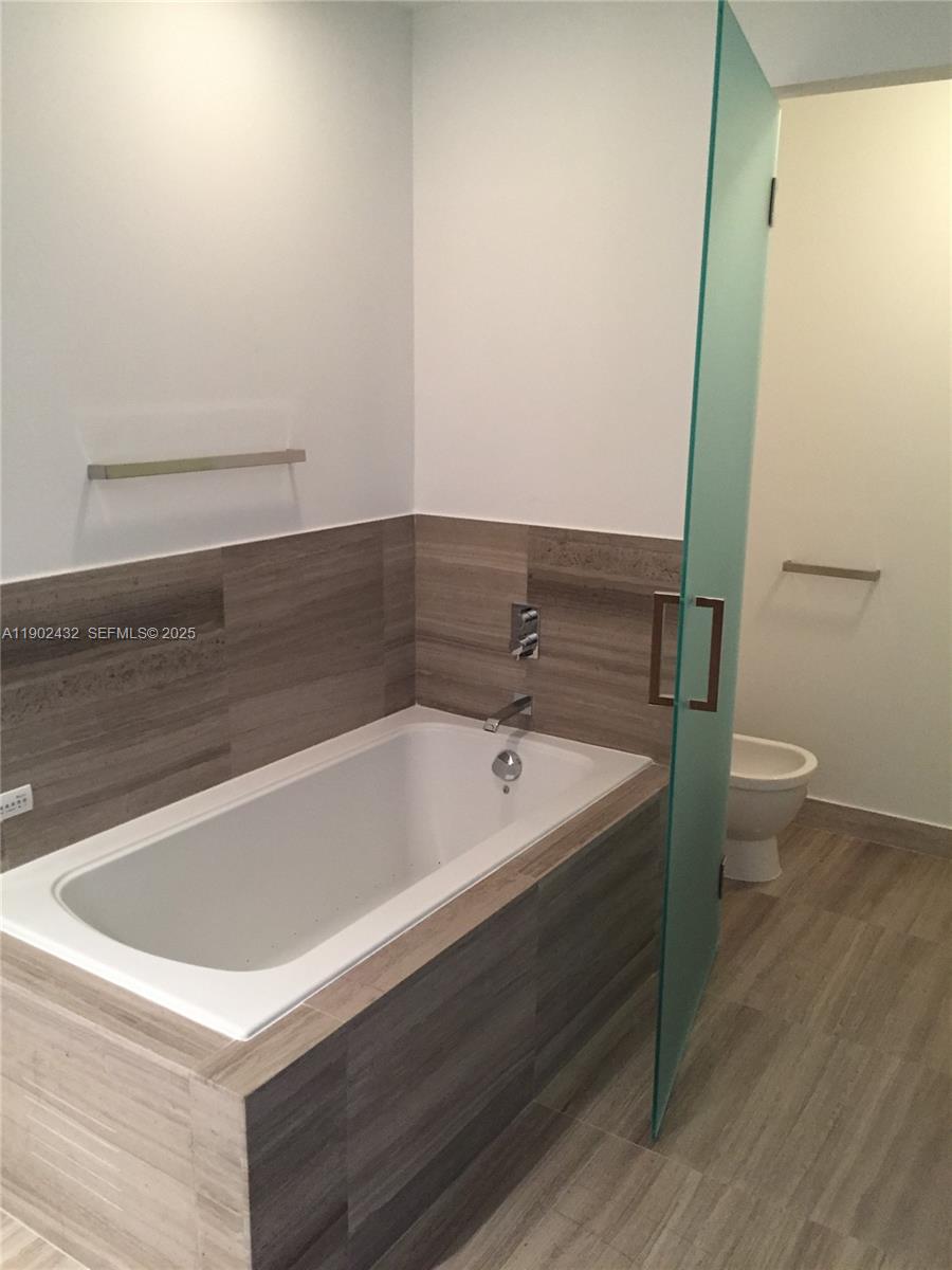 350 Ocean Drive, Unit 704N Key Biscayne, FL 33149 - Photo 23 of 34 a bathroom with a bathtub and toilet