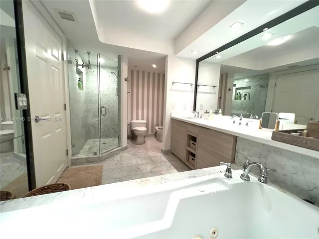 a spacious bathroom with a sink a large mirror and shower