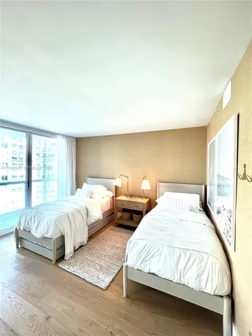 a spacious bedroom with two beds and a large window