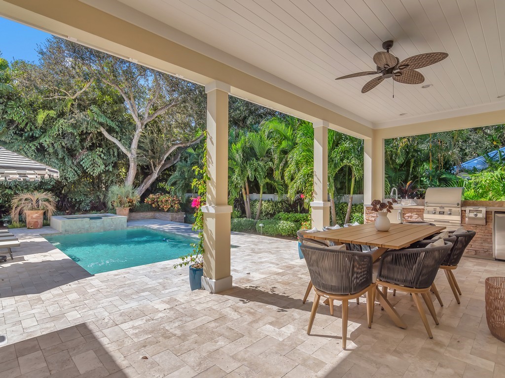 a view of a patio with a table chairs and a yard