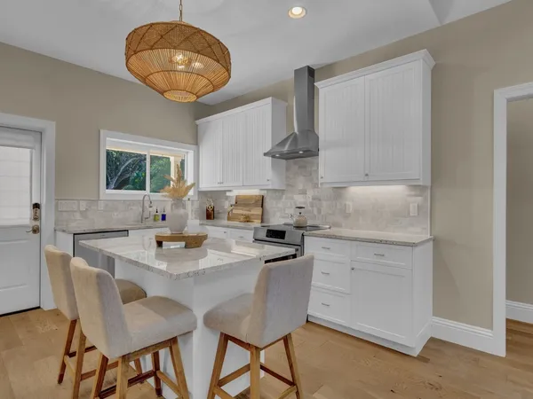 a kitchen with a table chairs and white cabinets